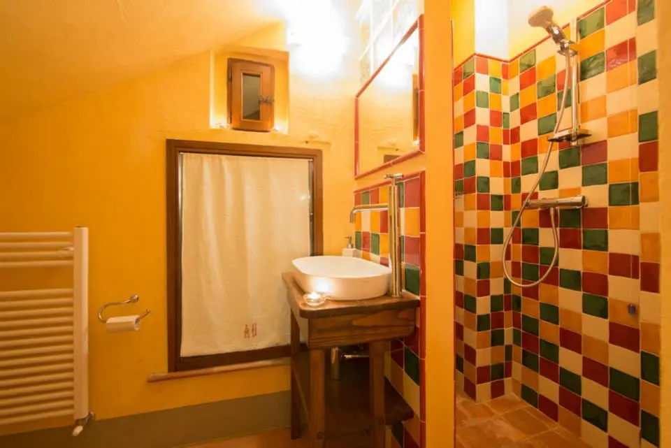Bagno con doccia a mosaico colorato