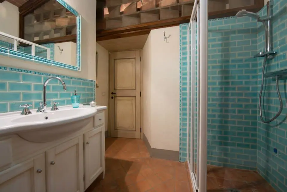 Bagno con doccia e piastrelle turchesi