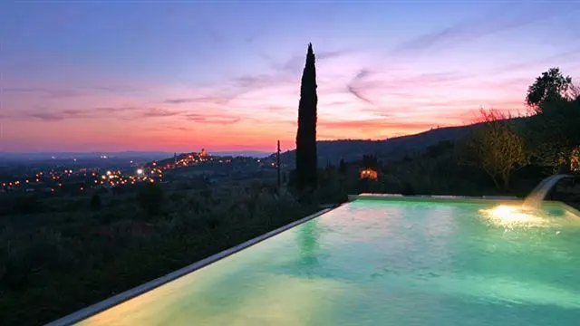 La cascata della piscina in un tramonto rosa
