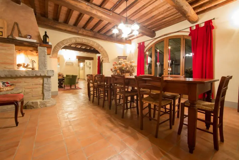 La sala da pranzo con camino e travi a vista